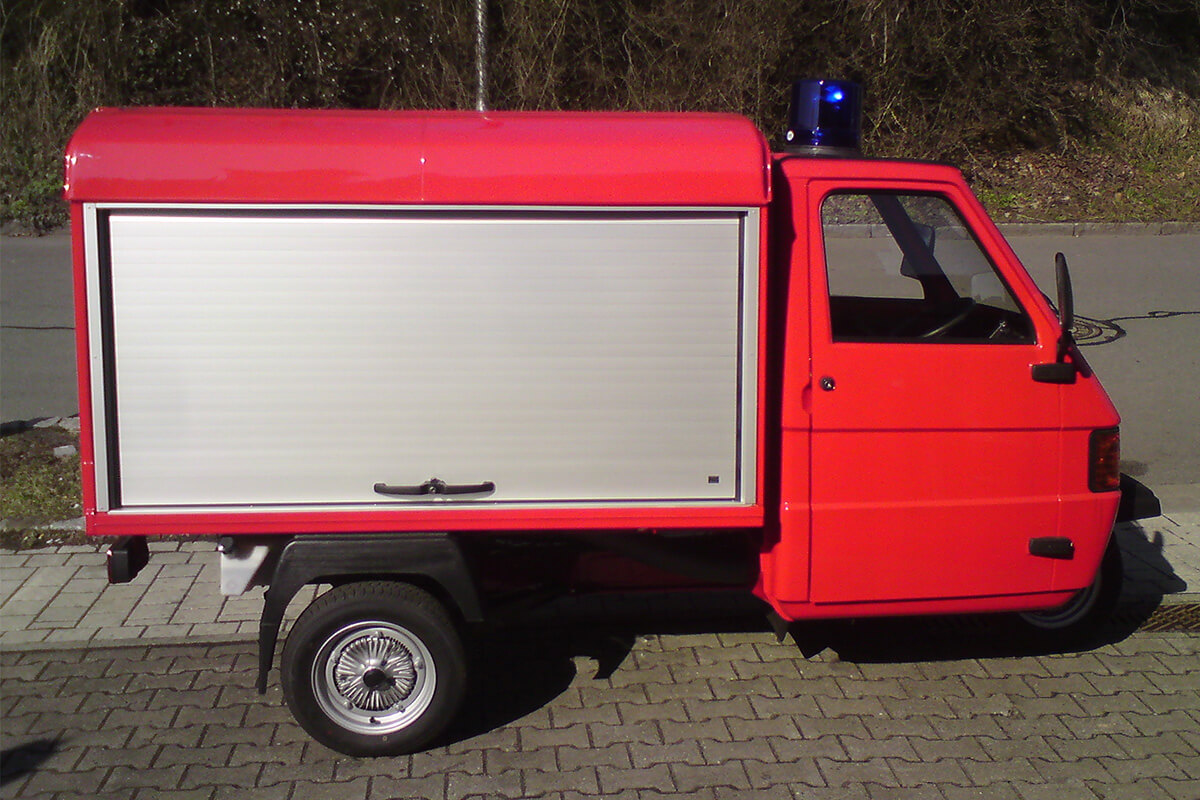 Eine Seitenansicht eines Piaggio Ape in rot.