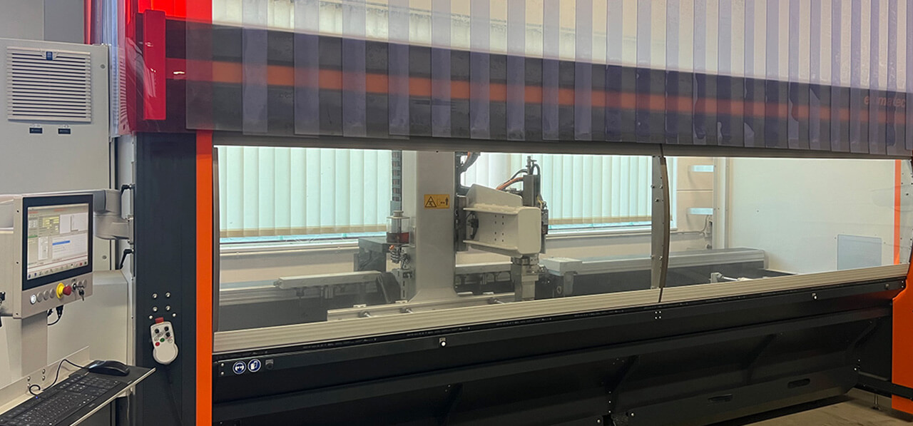 Großes CNC-Bearbeitungszentrum mit transparenter Schutzabdeckung und seitlichem Bedienpult.